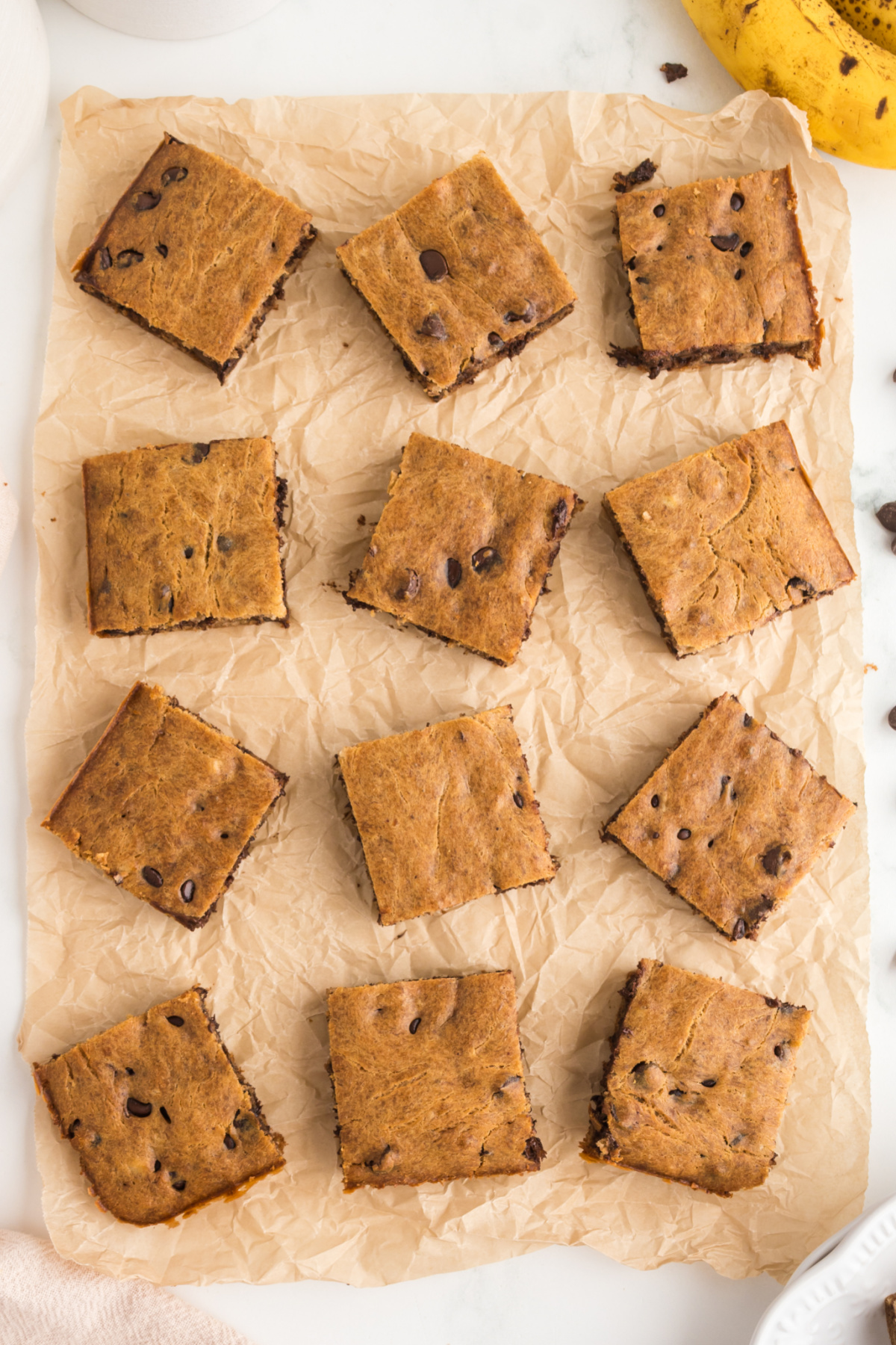Twelve blondies cut in squares on parchment paper