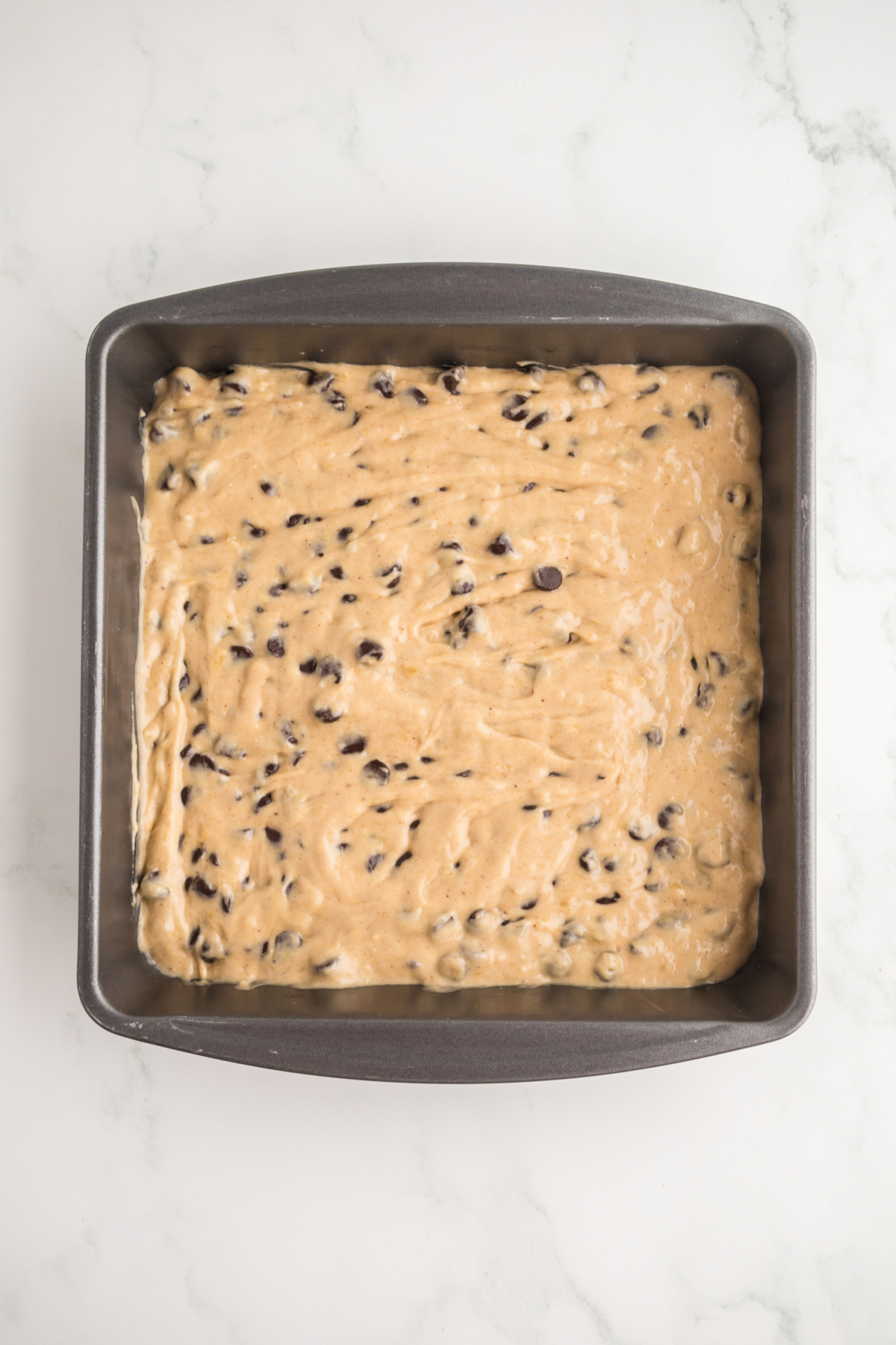 Chocolate chip filled batter in prepared 8x8 inch pan.