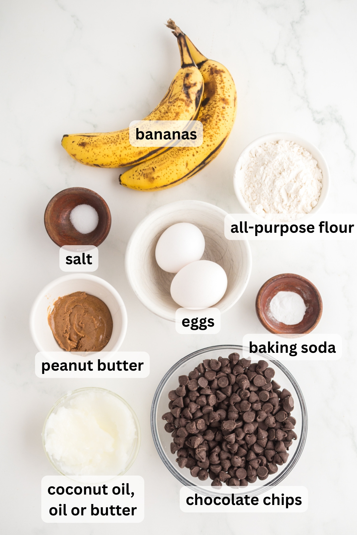 All of the ingredients needed to make banana blondies in bowls on a table.