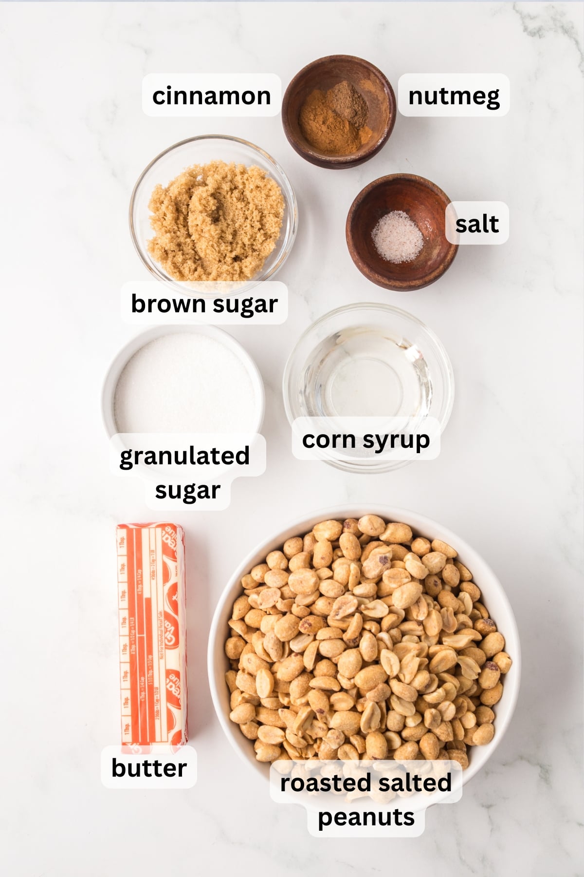 Ingredients for homemade butter toffee peanuts arranged in small bowls on a table