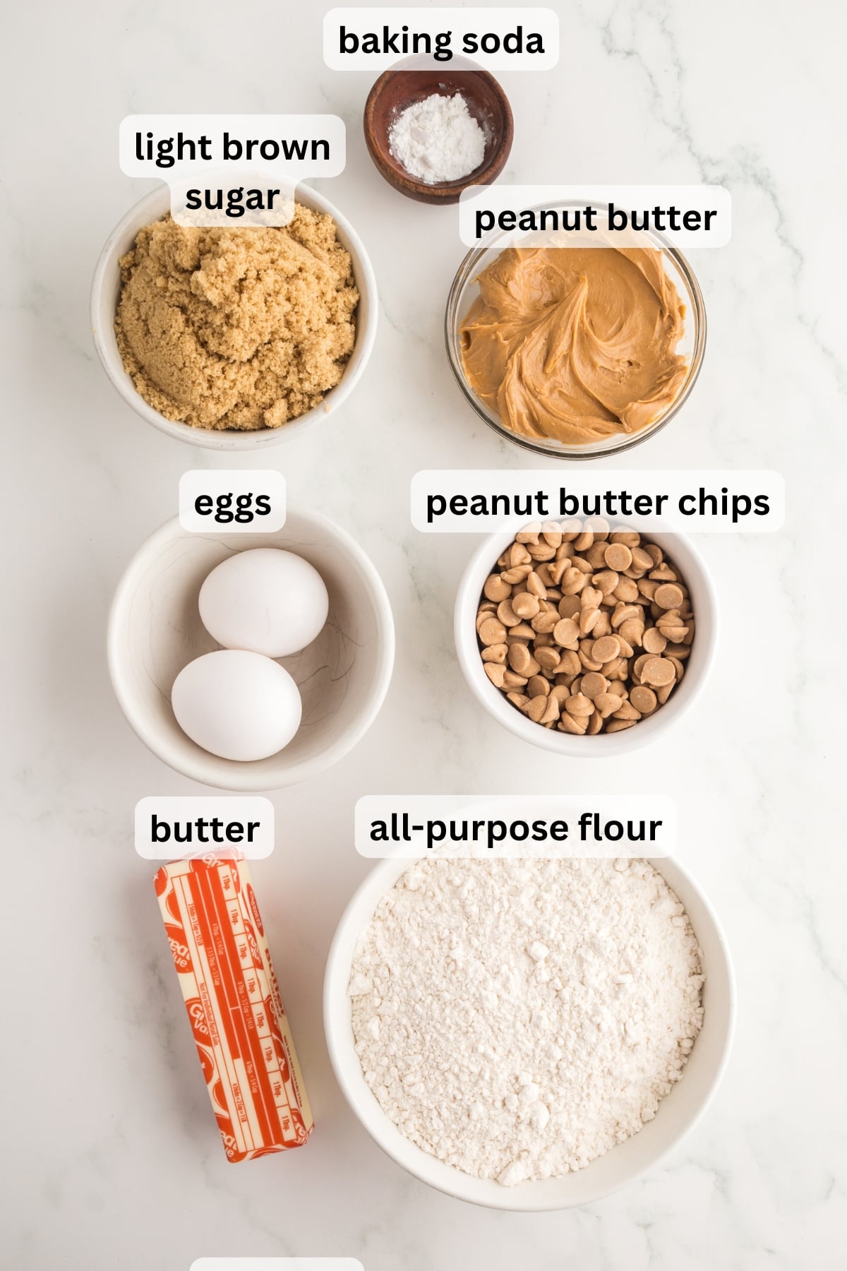 All of the ingredients needed to make peanut butter blondies in bowls on a table.