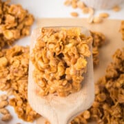 Peanut Butter Crunch Cookie lifted with a spatula above a tray of freshly made cookies.