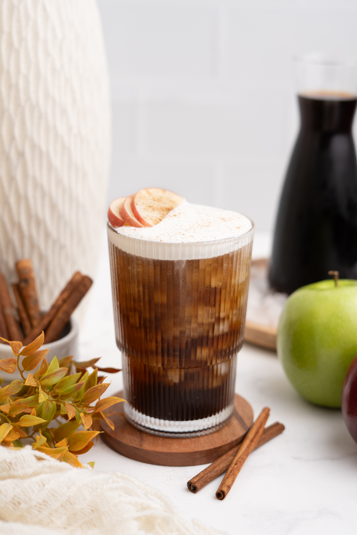 Drink garnished with apple slices and a pinch of cinnamon.