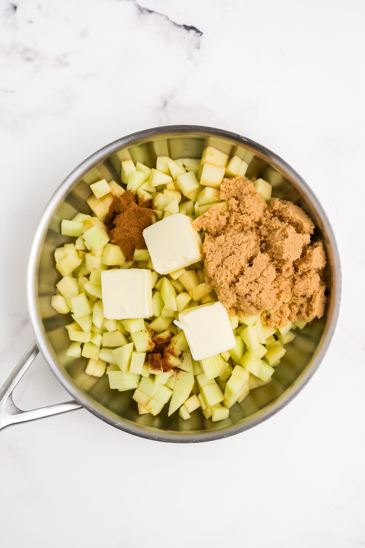 All of the ingredients needed to make apple filling in pan.
