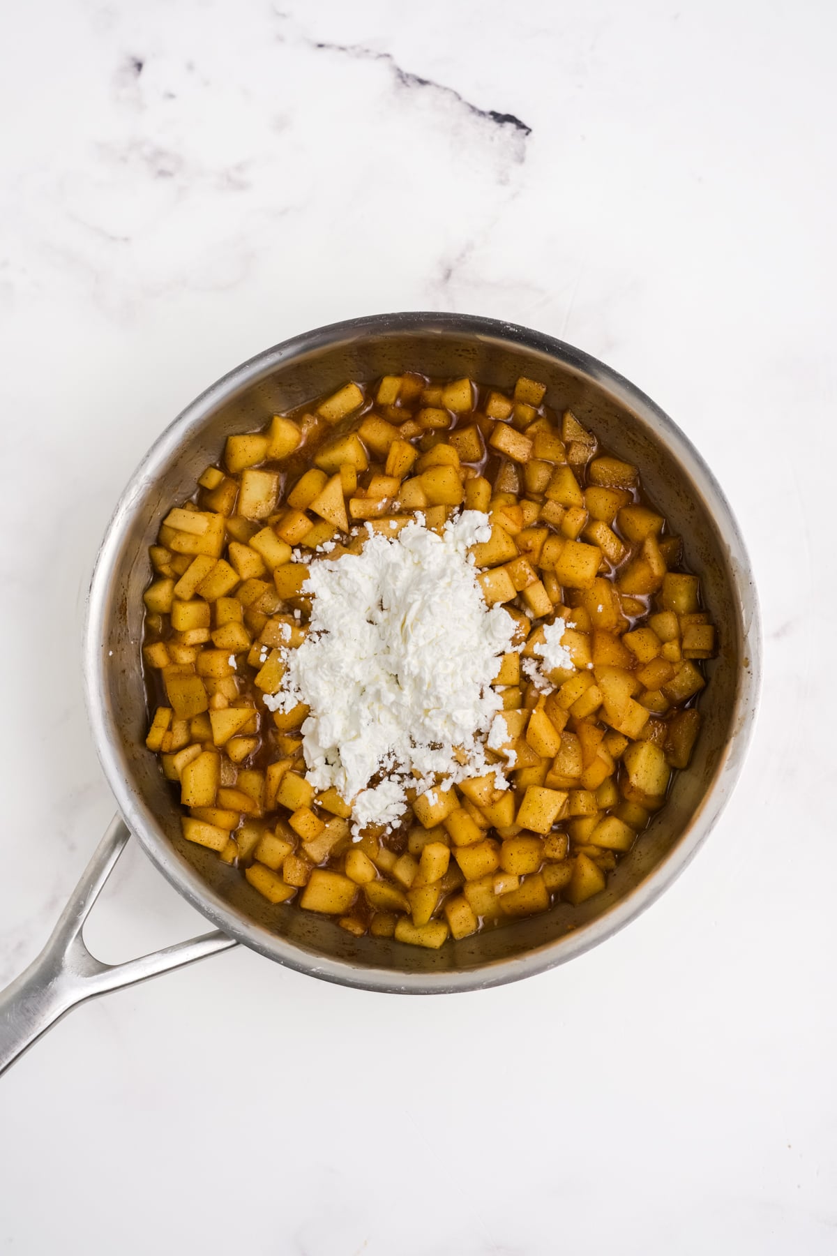 Apple mixture in pan with cornstarch sprinkled on top.