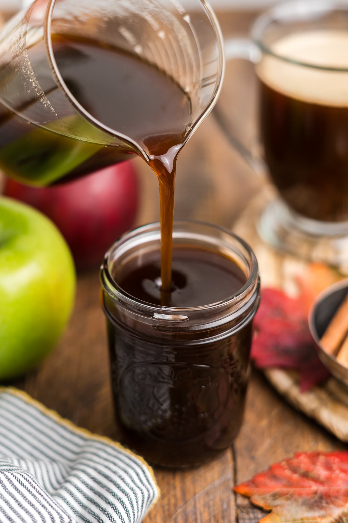 Pouring syrup into a mason jar for storage.