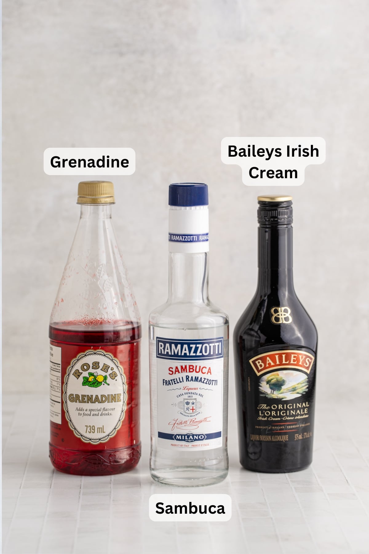 All of the ingredients needed to make a Baileys Shooter in bottles on a table.