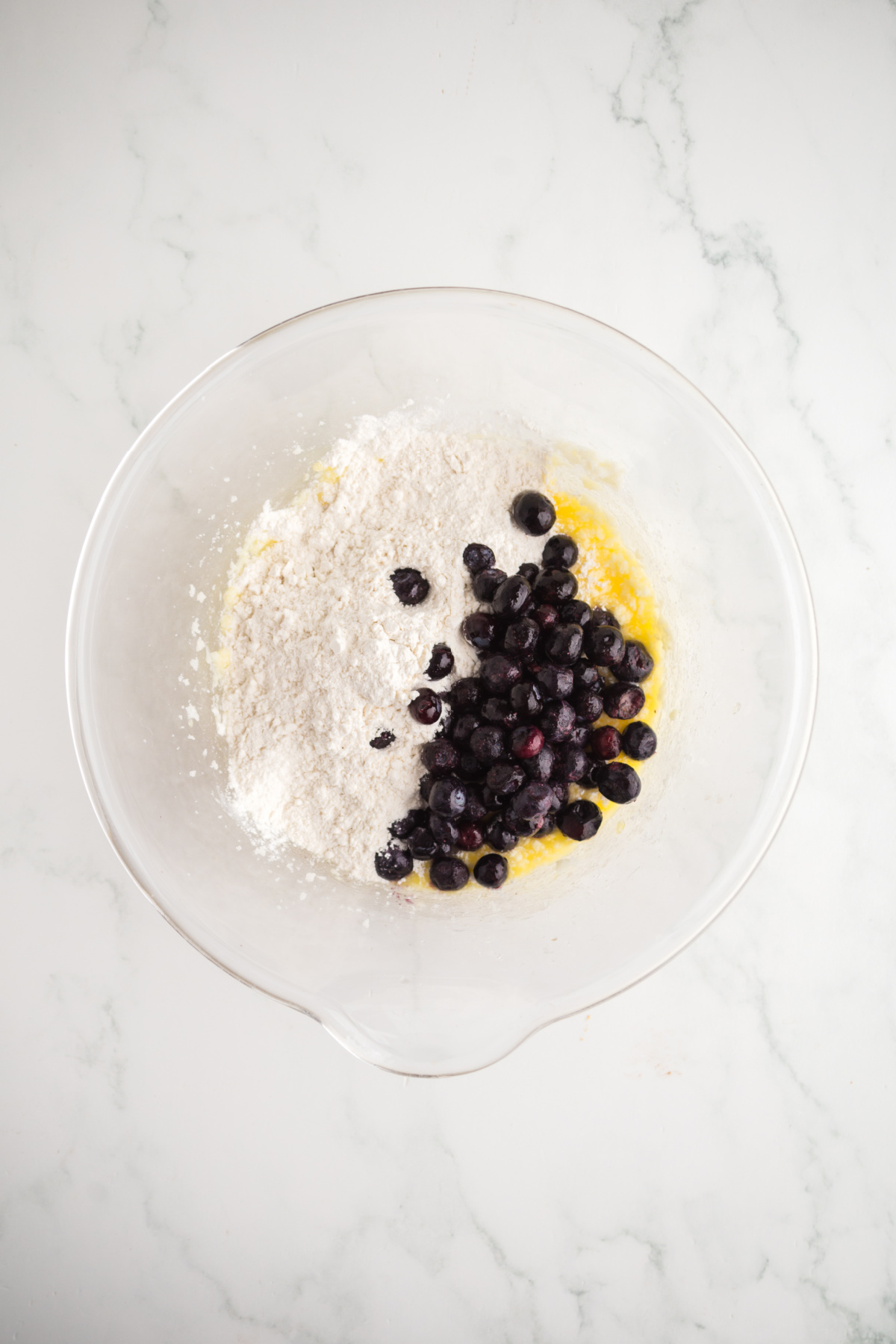 Dry ingredients added to wet ingredients and flour coated blueberries to create batter.