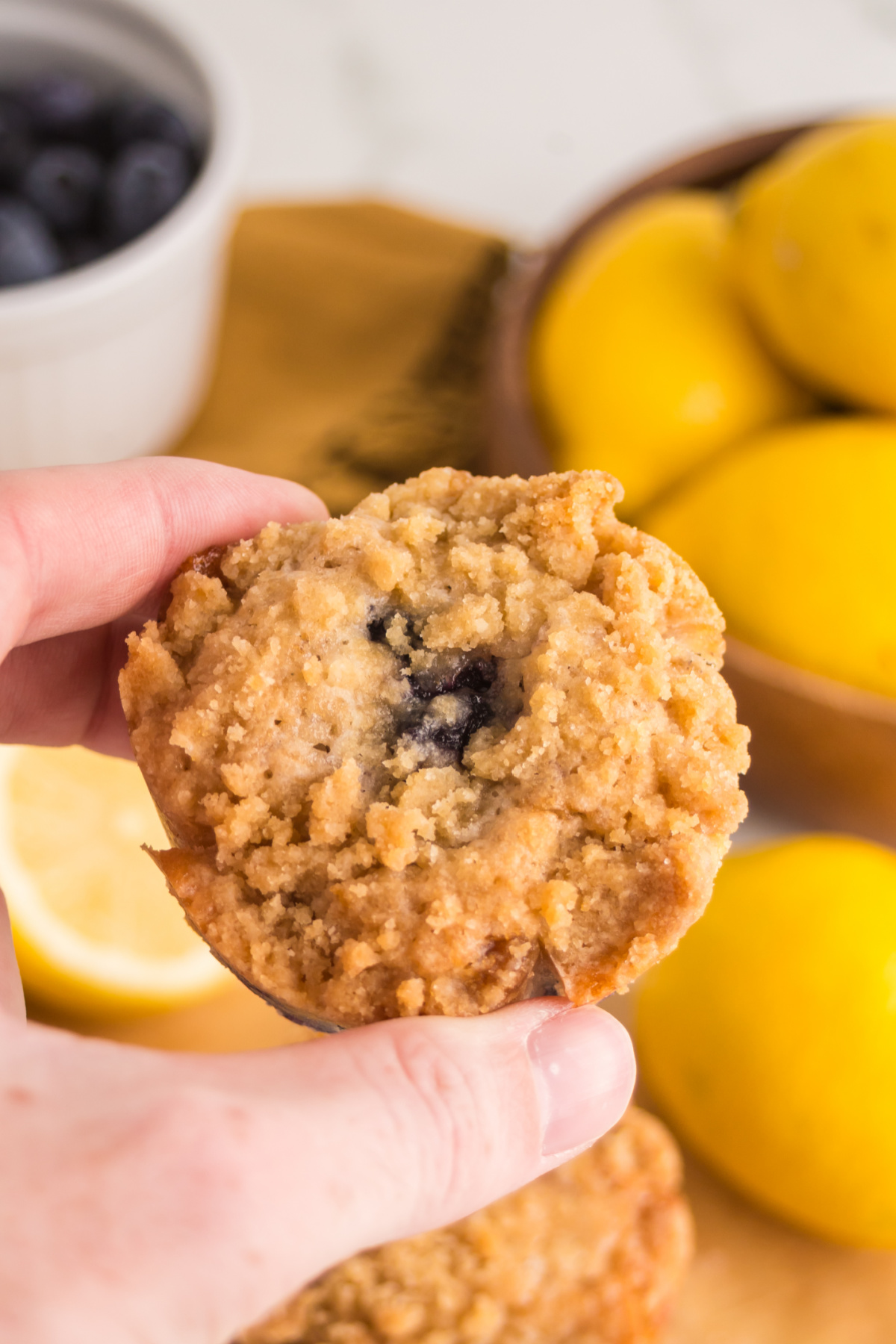 A muffin held in the air ready to eat.