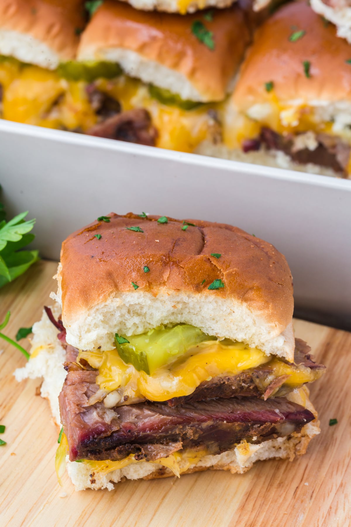 Slider on a wooden cutting board with more sliders in the background.