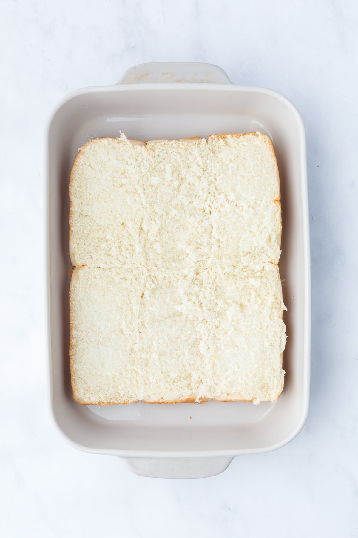 Hawaiian slider rolls ready to toast in a baking dish.