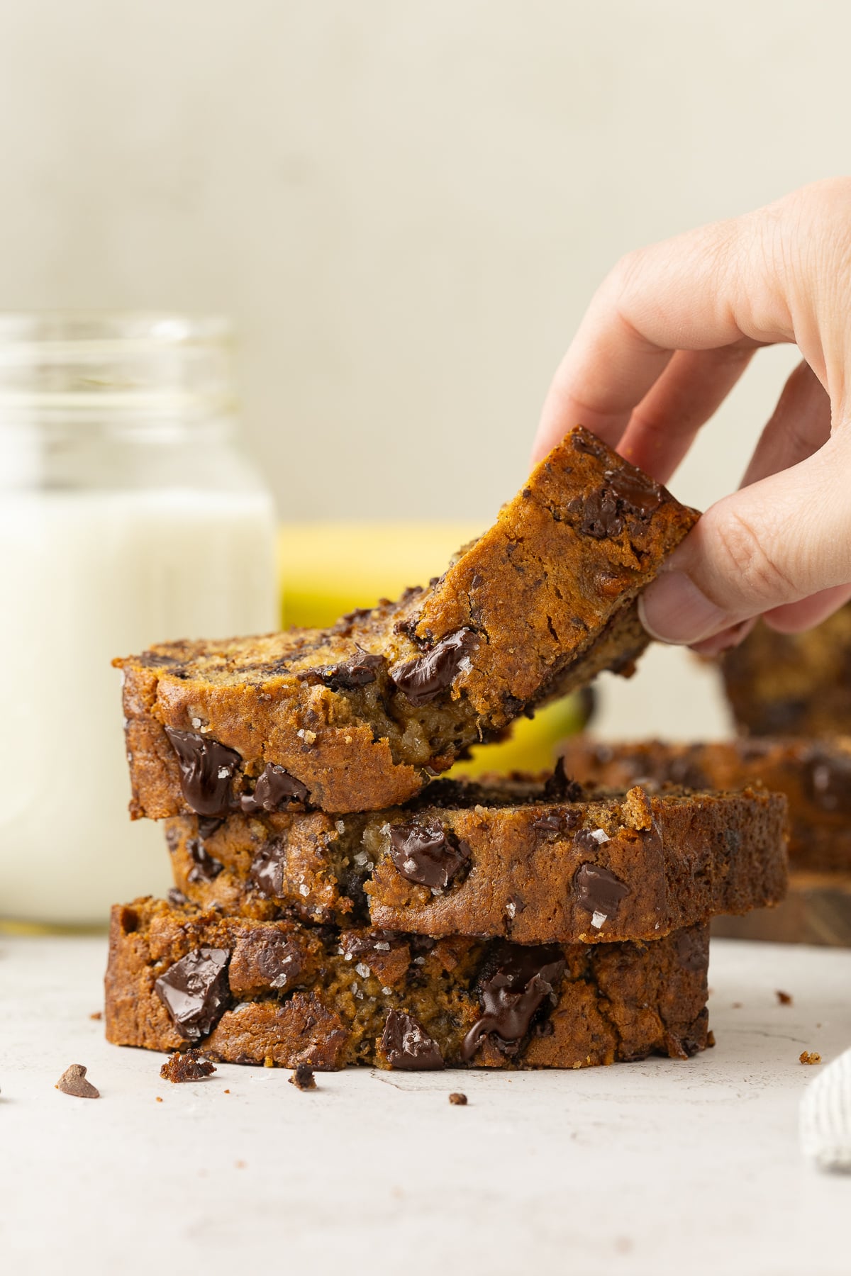 A stack of 3 slices of banana bread with top slice being lifted up.