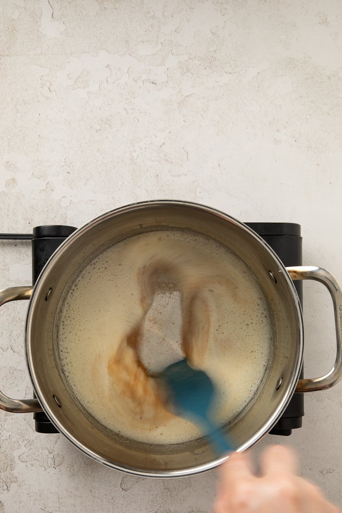 Brown butter being browned in a saucepan until nutty.