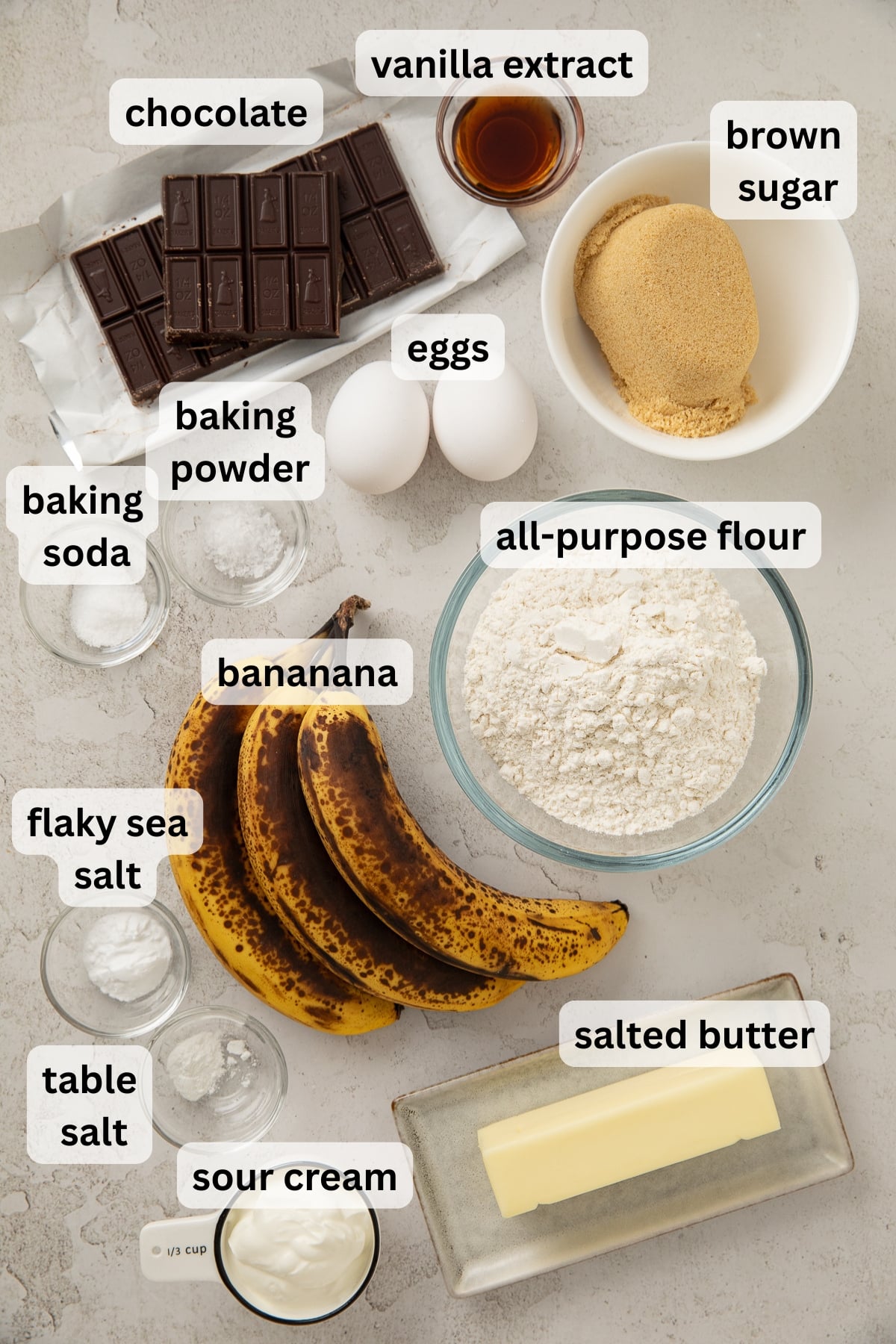 All of the ingredients needed for brown butter banana bread in bowls on a table.