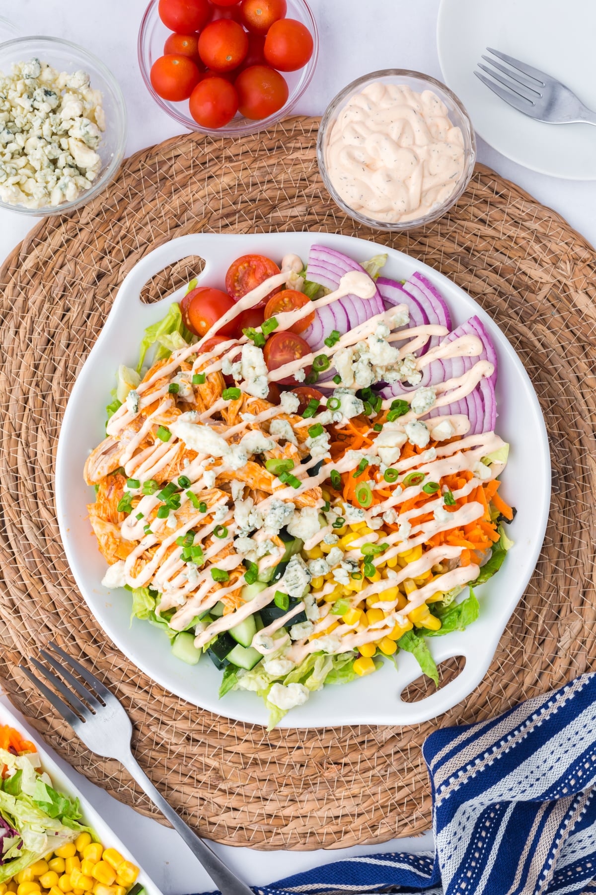 Salad topped with homemade buffalo ranch dressing, blue cheese crumbles, and green onions.