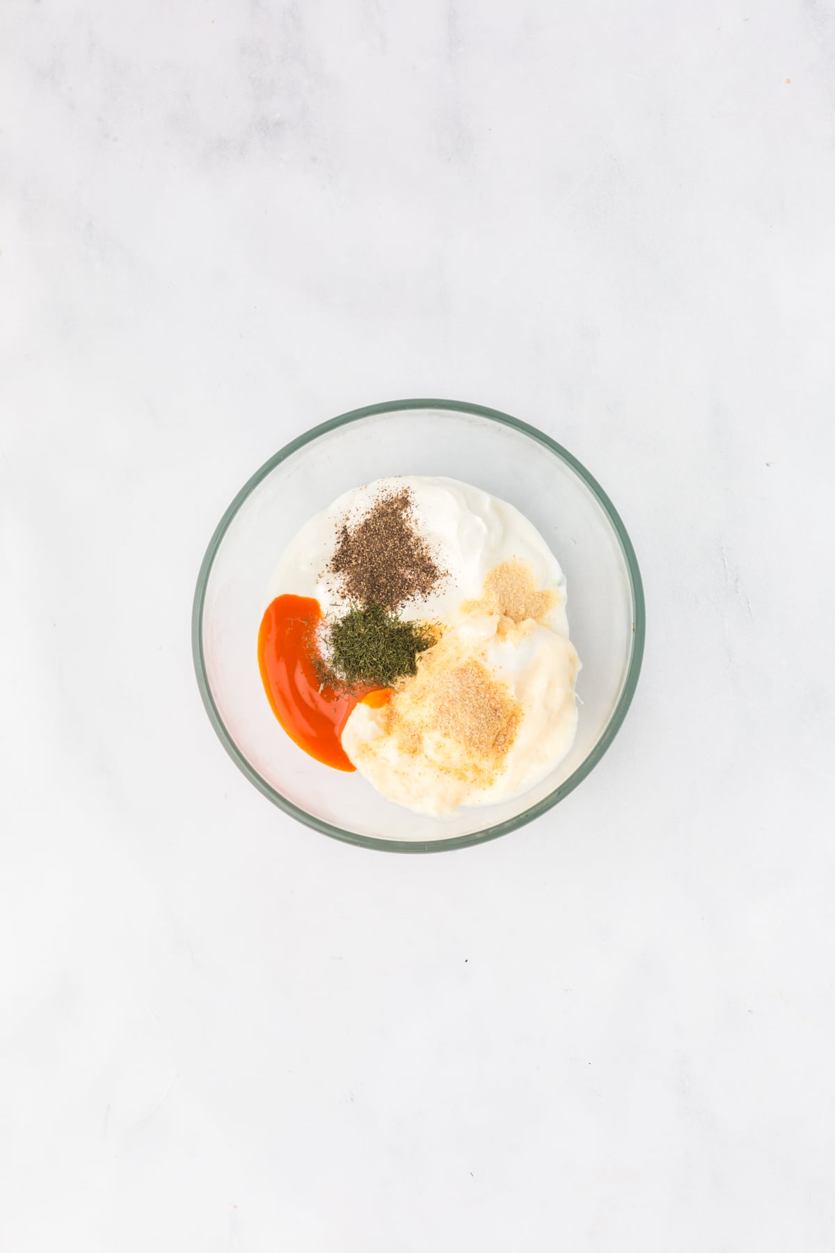 Homemade buffalo ranch dressing being whisked together in a small bowl.
