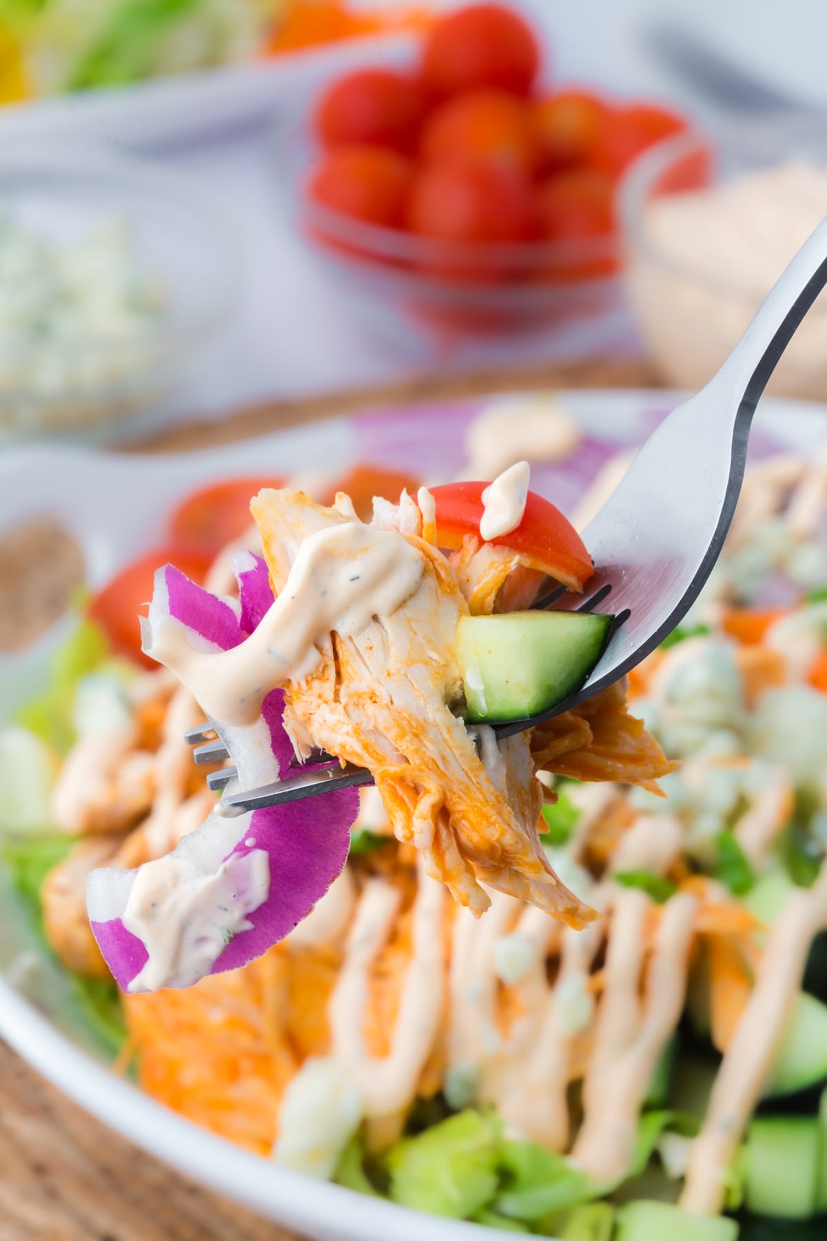 a forkful of salad held above a serving bowl.