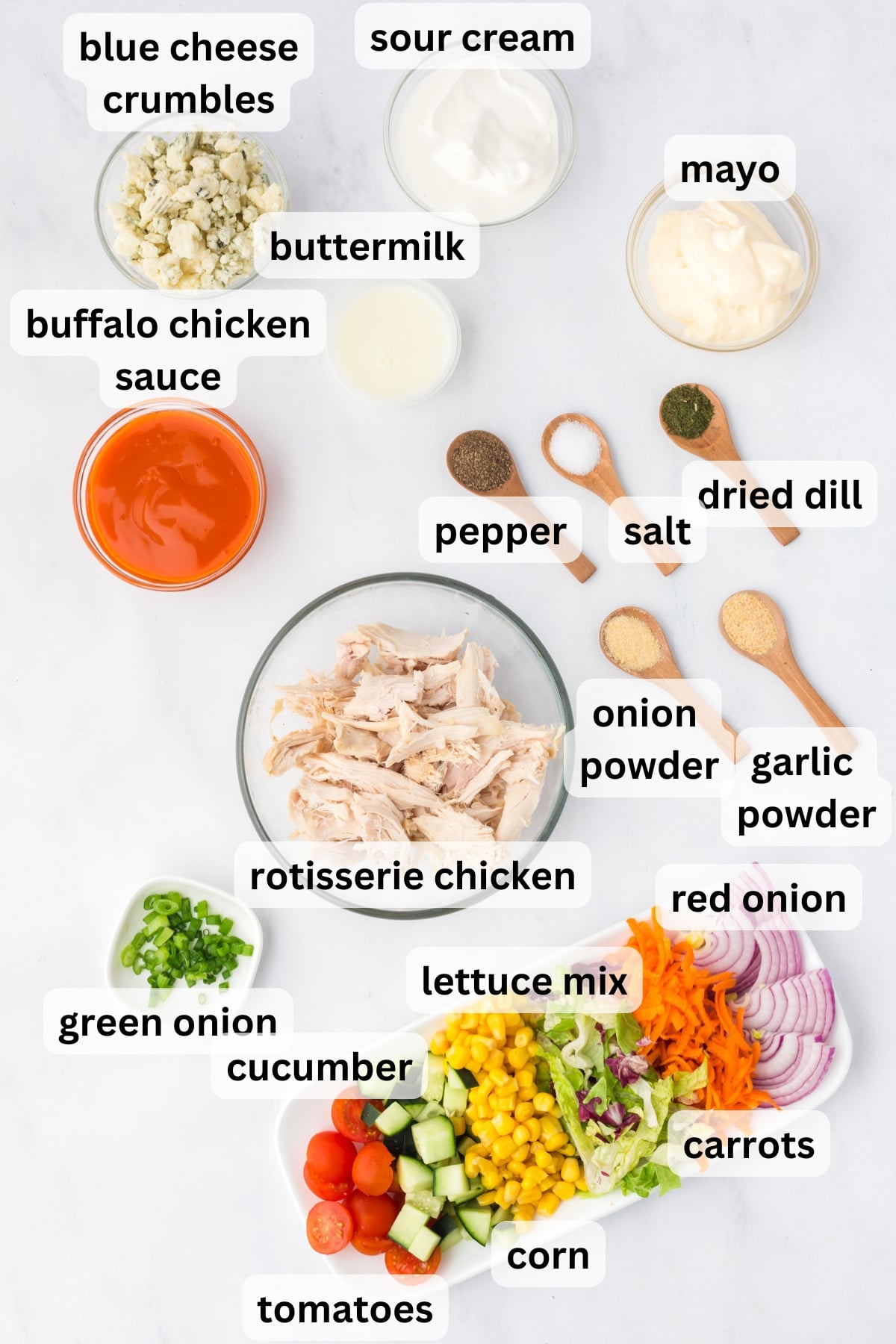 Ingredients needed to make a Buffalo Chicken Salad in bowls on a table.