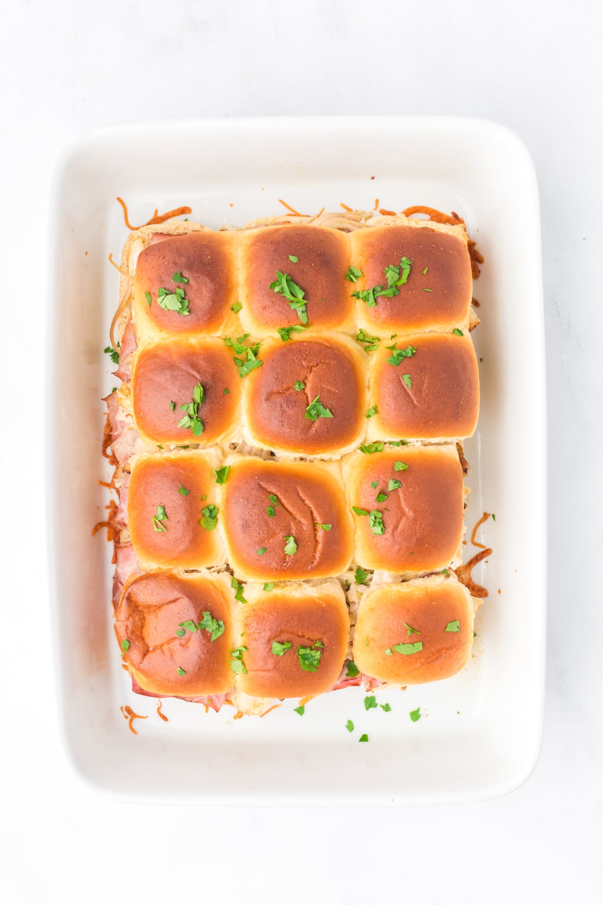 baked sliders fresh from the oven sprinkled with parsley.