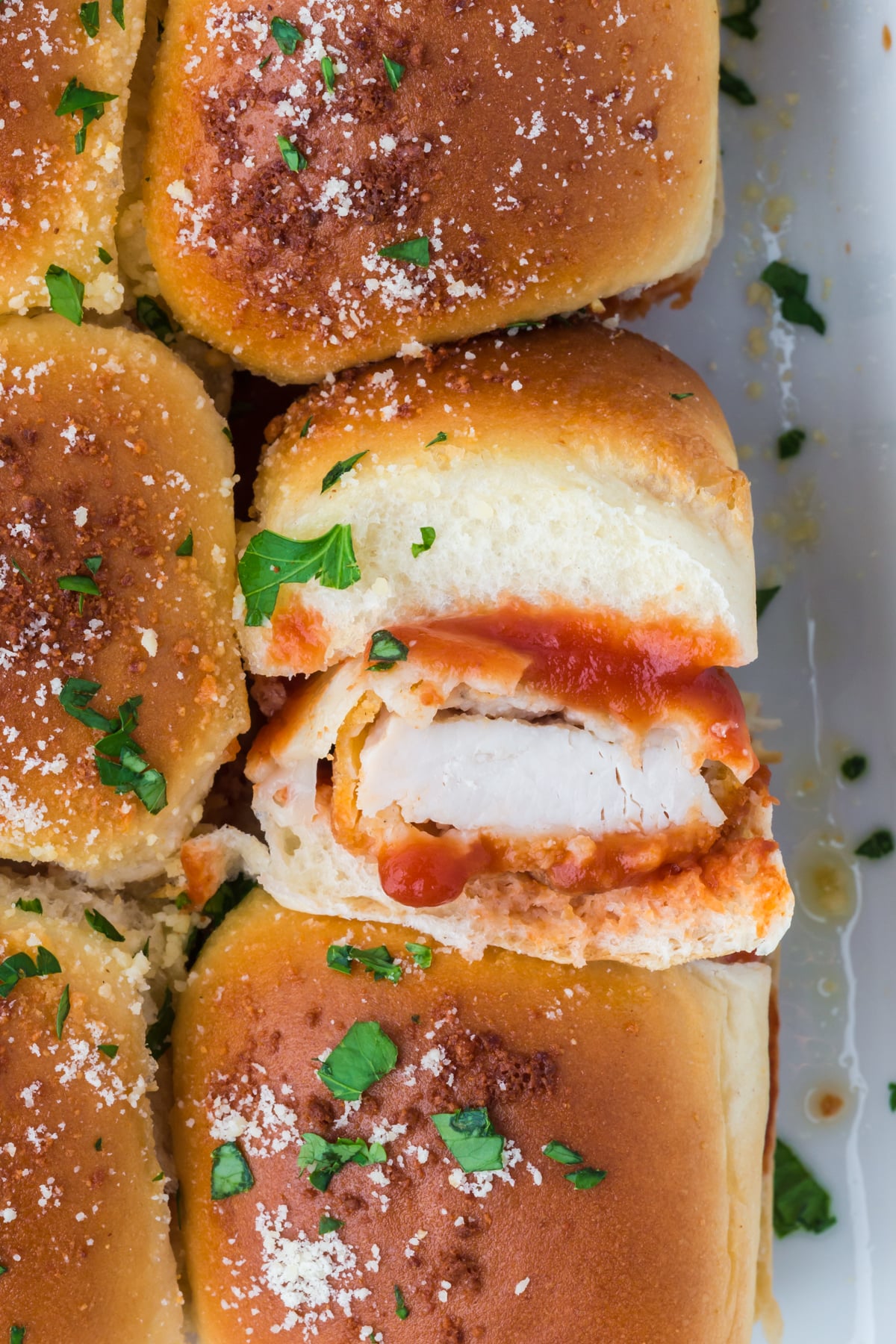 Sliders in casserole dish with one flipped on side.