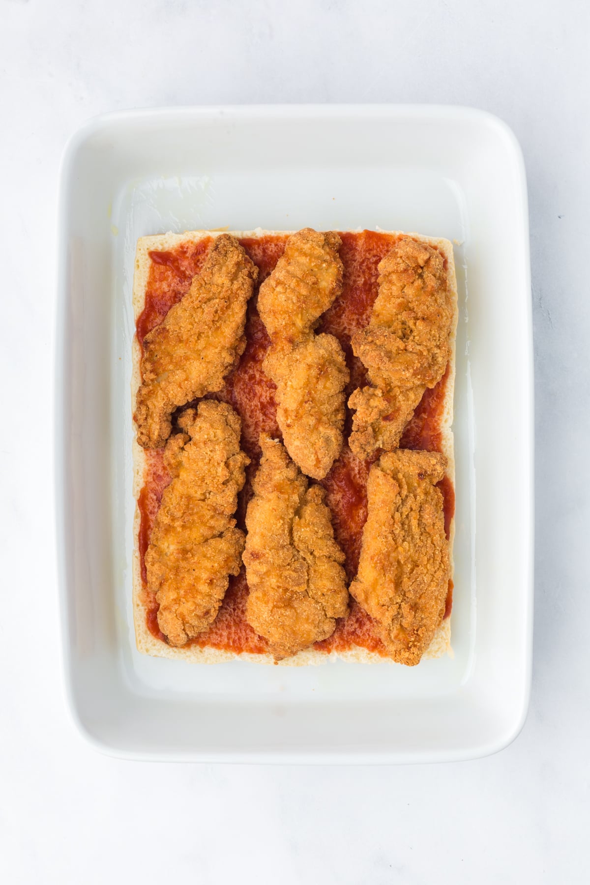 Toasted Hawaiian slider rolls layered with provolone cheese, marinara sauce and chicken tenders.
