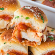 Chicken Parmesan Sliders in baking dish with one on top.