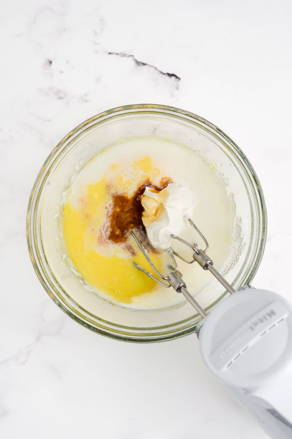 Milk and sour cream mixture being added to dry ingredients and wet ingredients with blender.