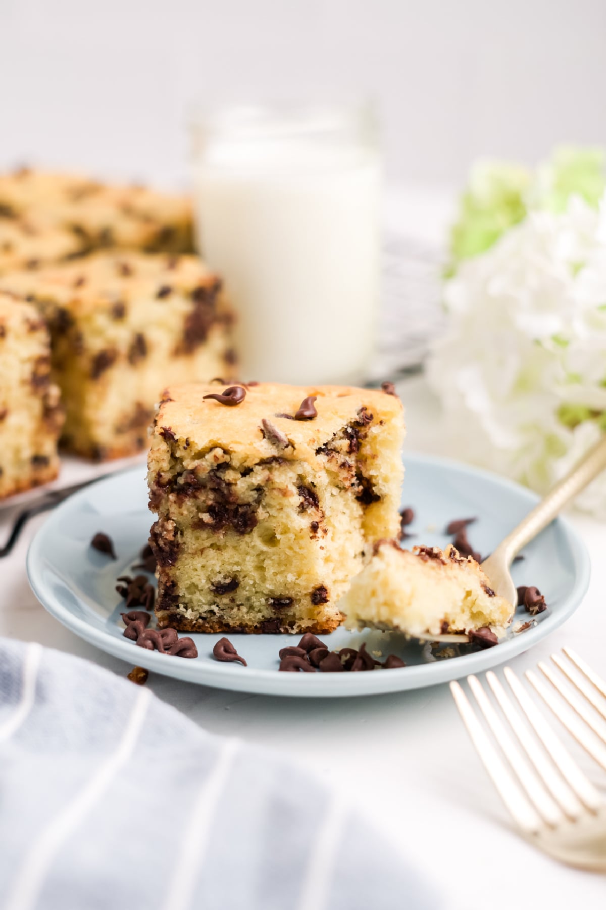 A slice of cake on a plate with a fork full of cake.