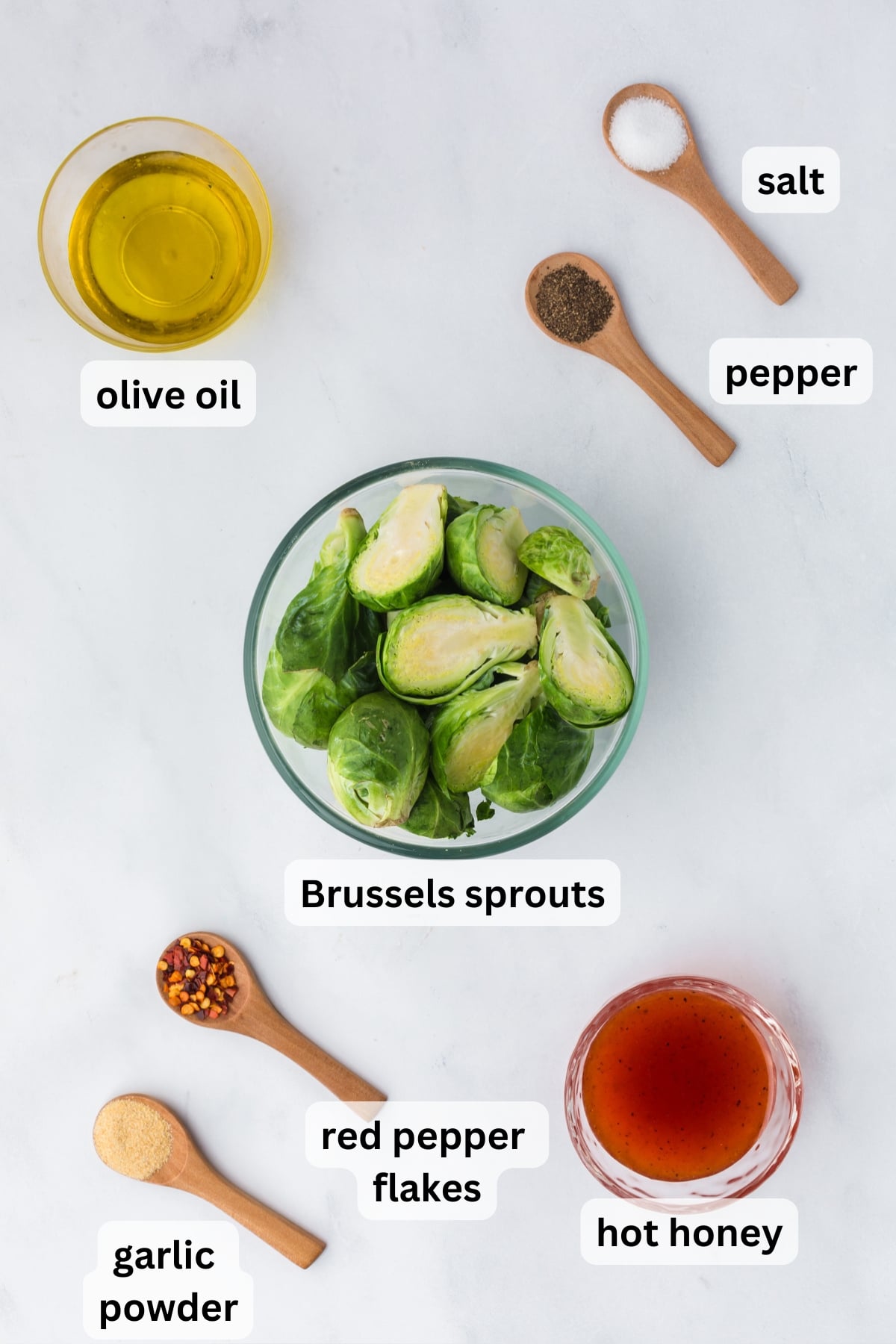 All of the ingredients needed to make Hot Honey Brussels Sprouts in bowls on a table.