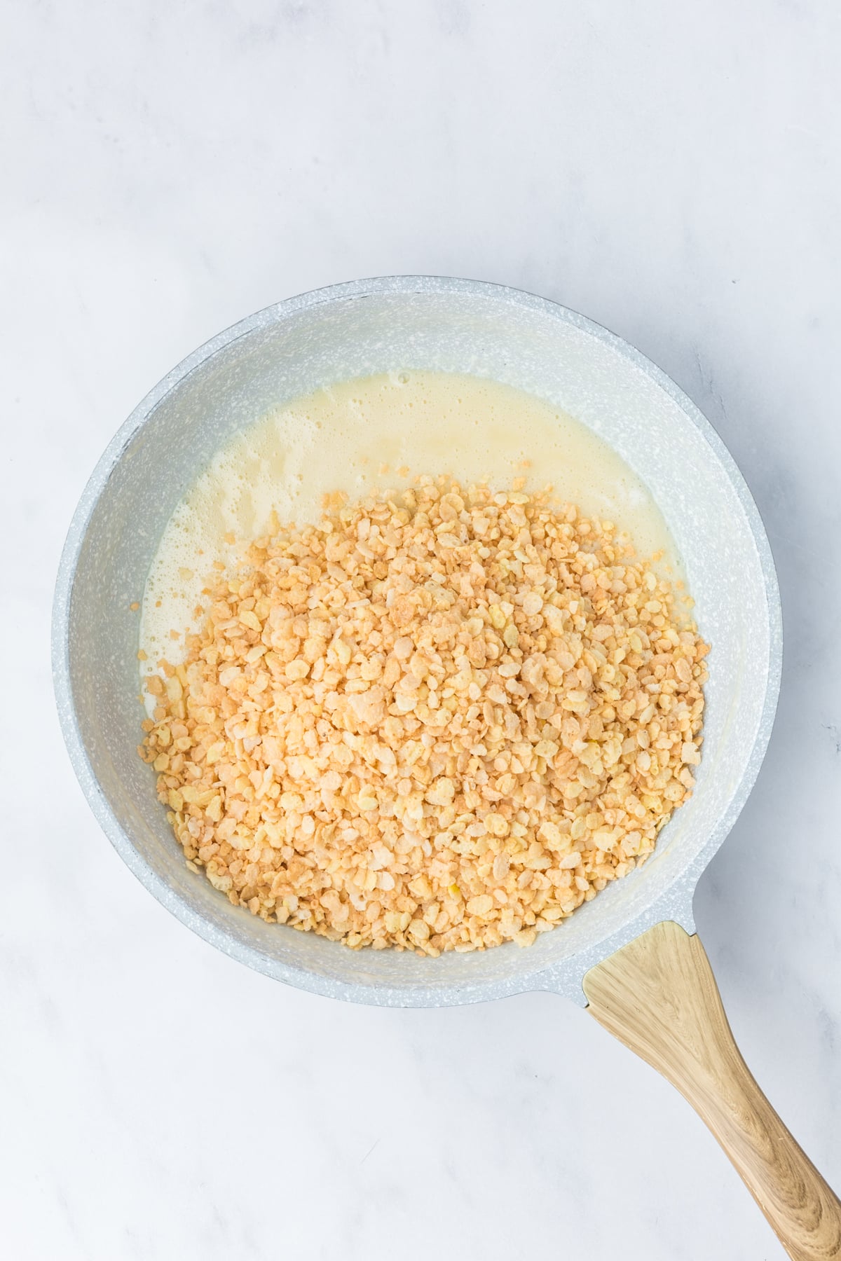 Melted butter and marshmallows in saucepan with cereal added.