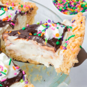A slice of Ice Cream Pie with Rice Krispie Crust being lifted out of the pie plate.
