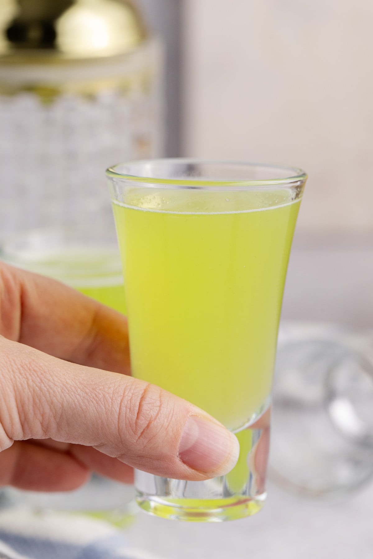 A hand holding a shot ready to drink.