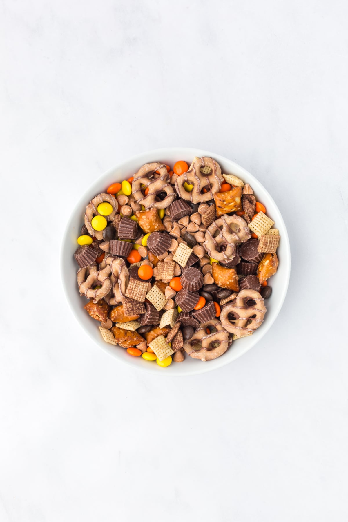 Trail mix ingredients tossed together in a large mixing bowl.