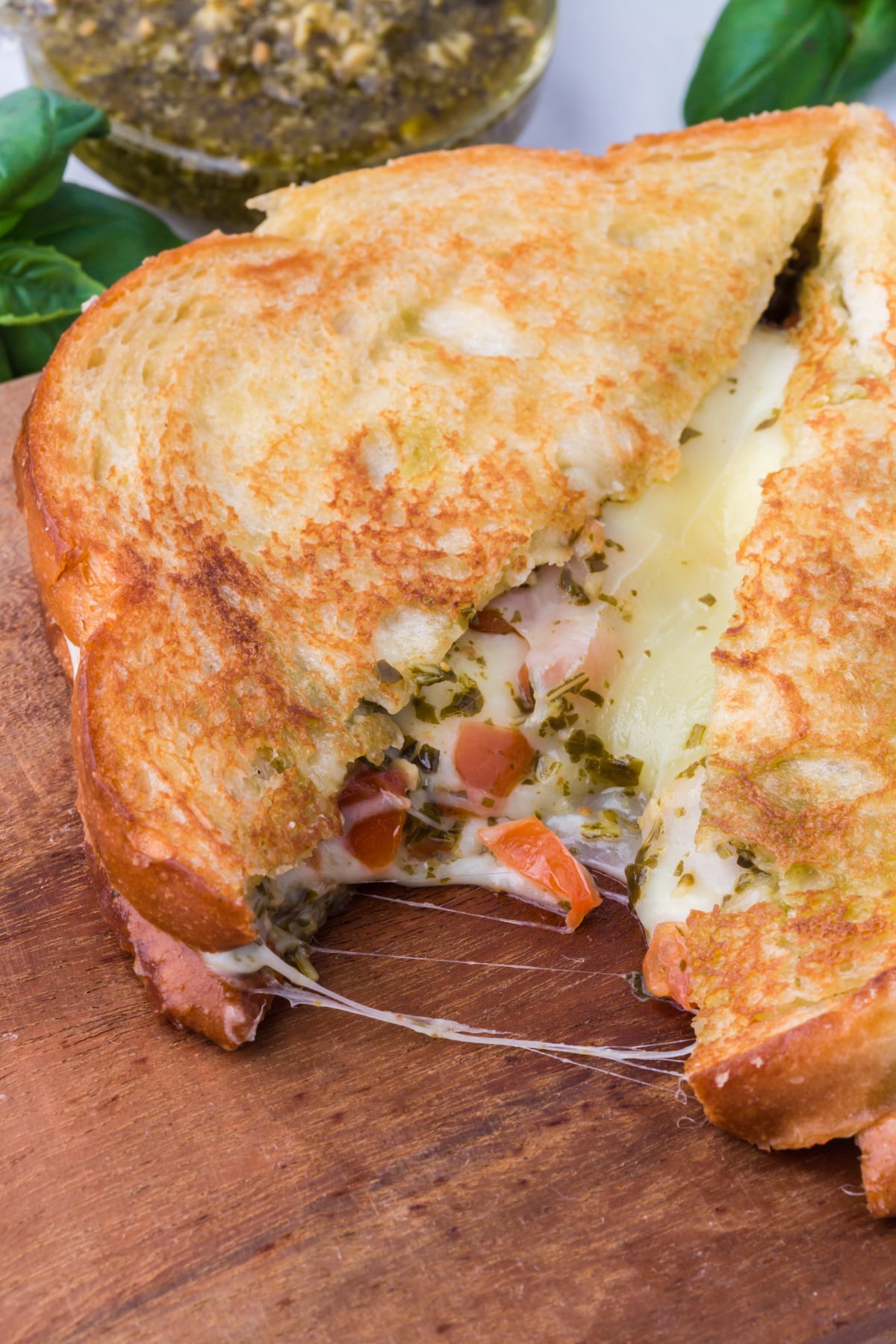 A grilled cheese cut in half on a cutting board.