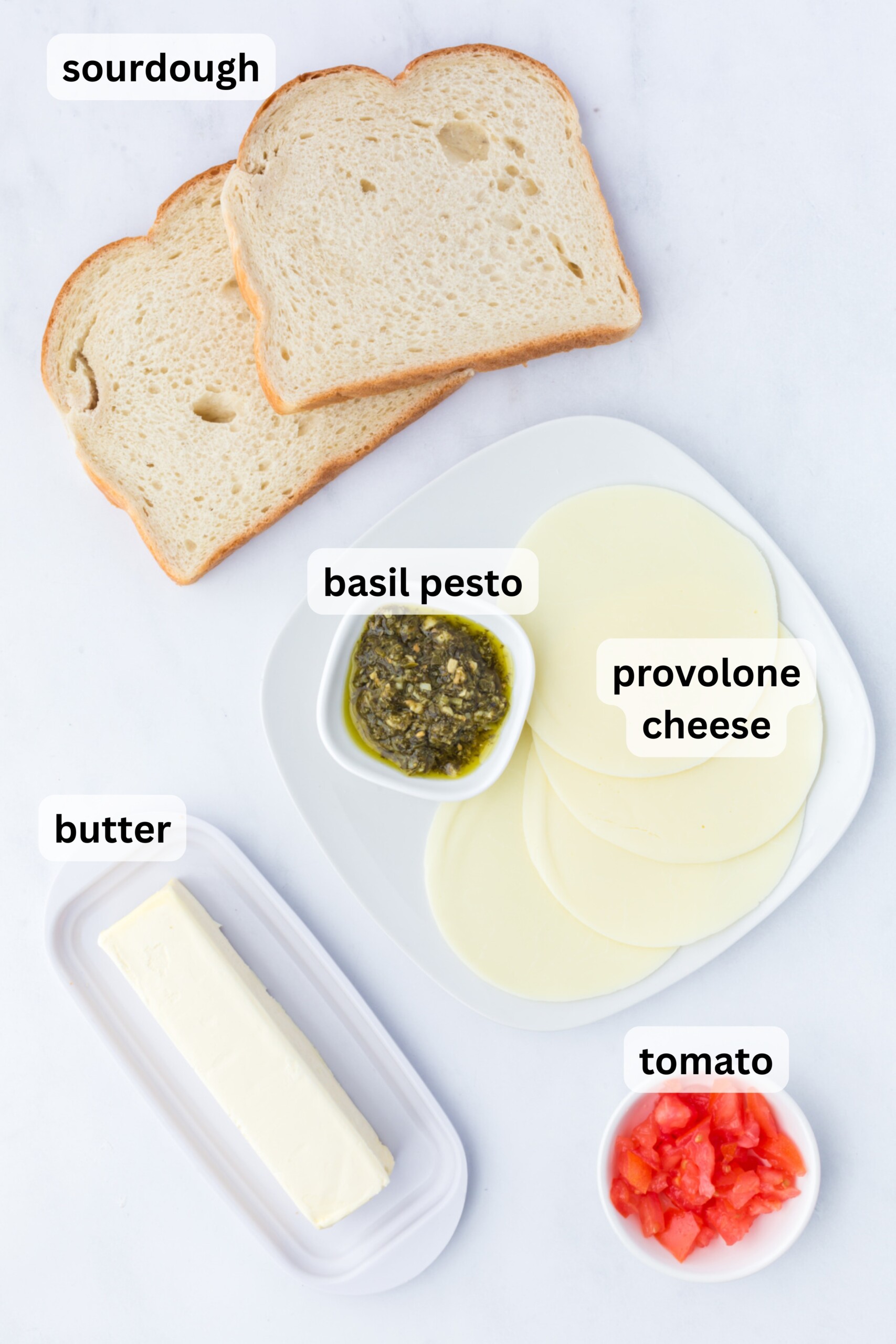 All of the ingredients needed to make pesto grilled cheese on a table.