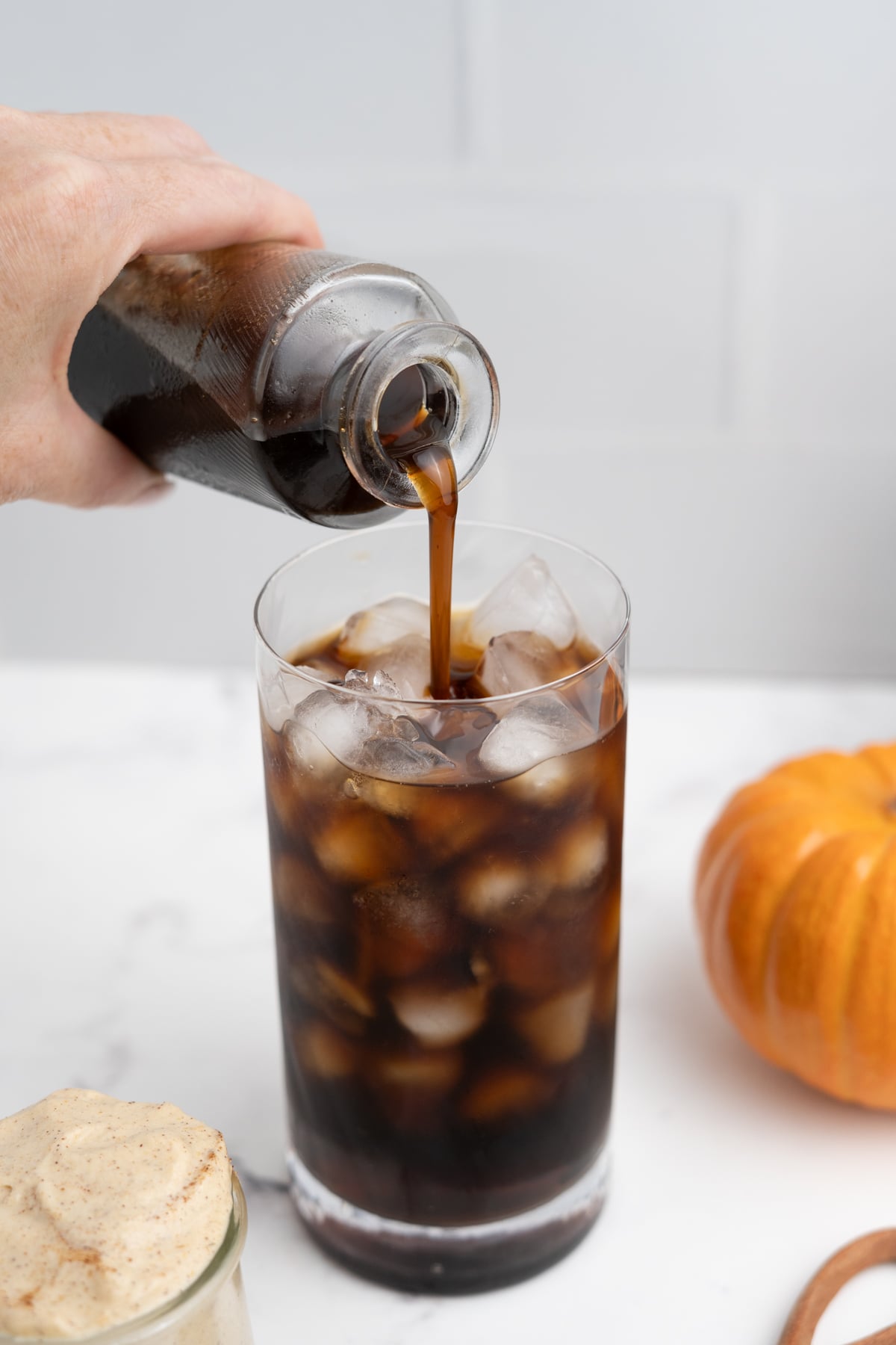 Pumpkin syrup is added to the glass with cold brew.