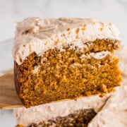 A slice of pumpkin olive oil cake being lifted from the whole cake.