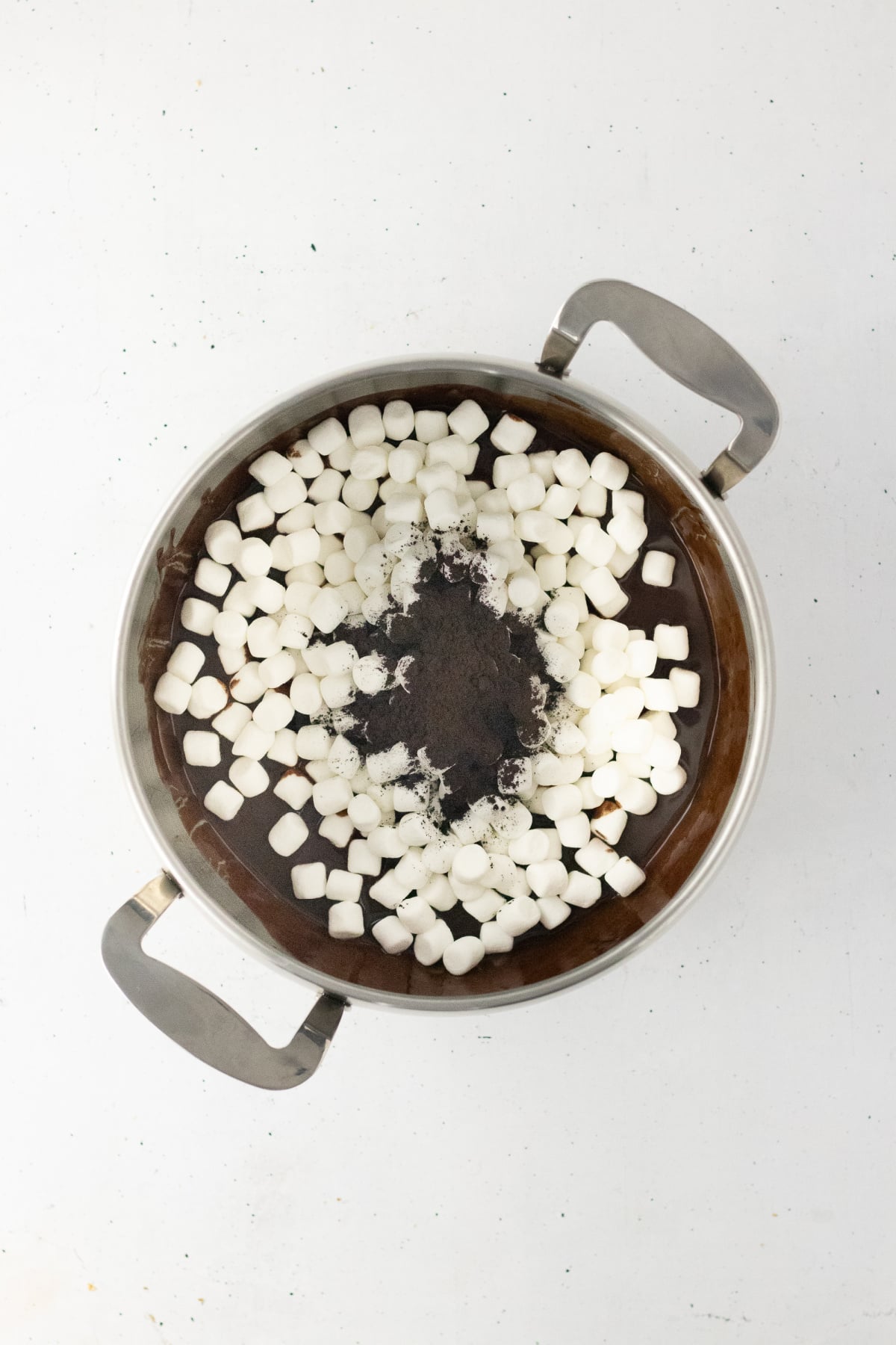 Cocoa powder and mini marshmallows added to melted chocolate.