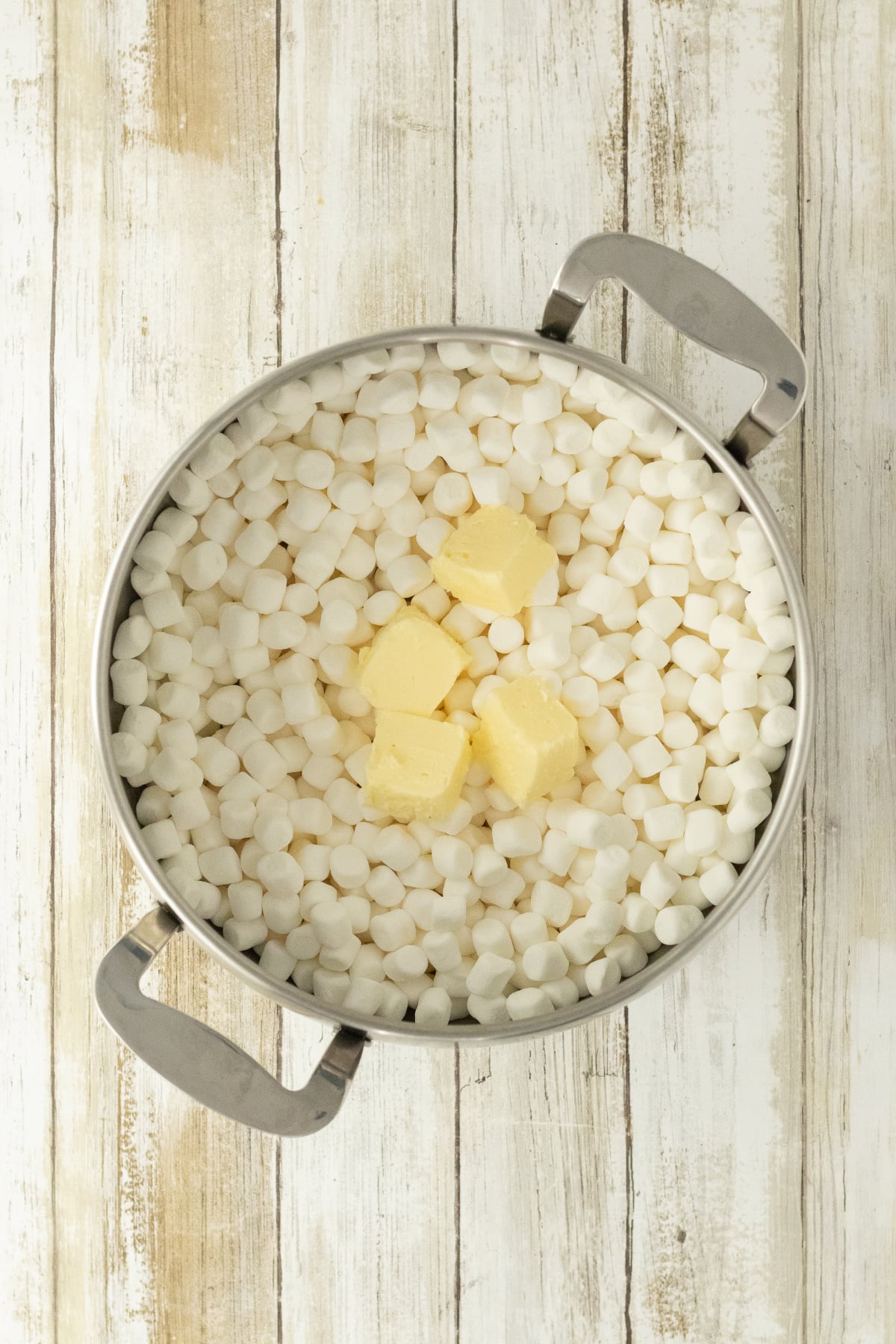 Butter and marshmallows in saucepan starting to melt.