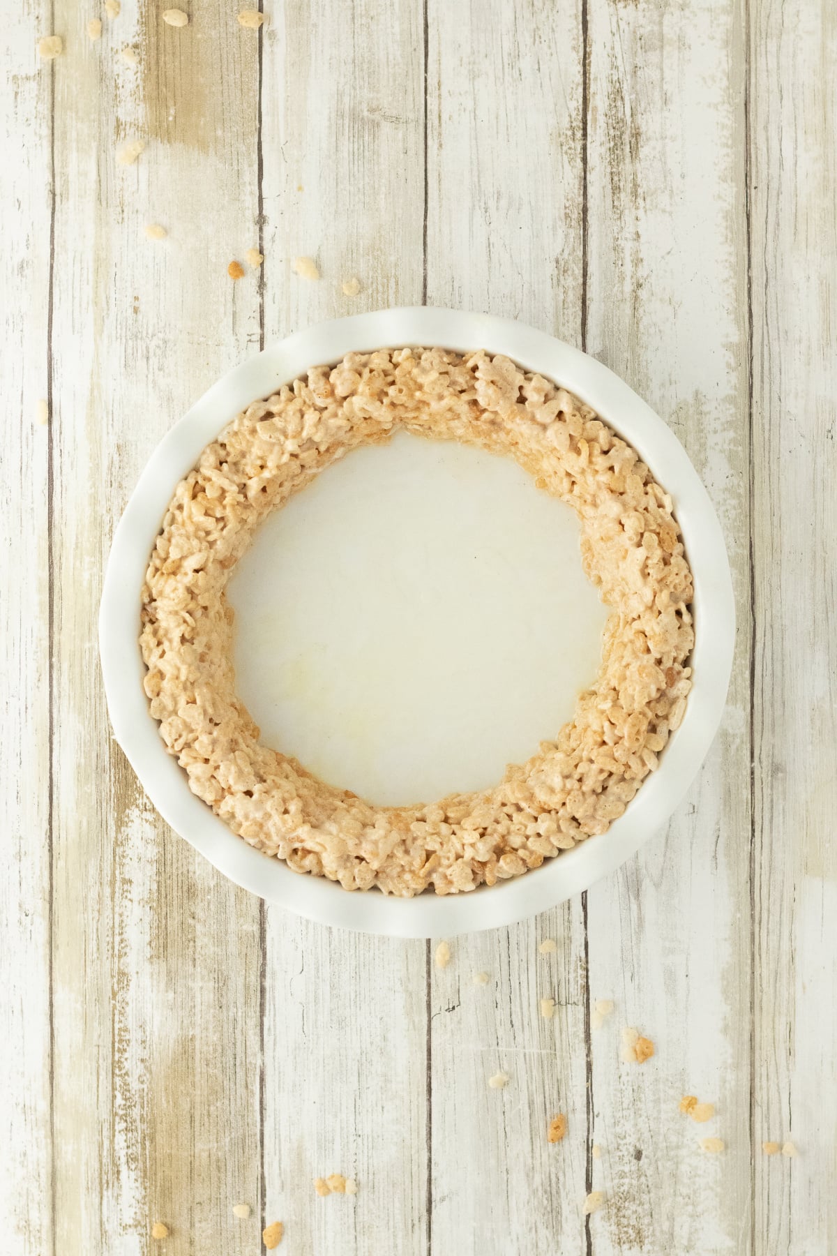 Some of the cereal mixture pressed around the outer edge to form a 1ยฝ-inch-wide crust, with an empty center.