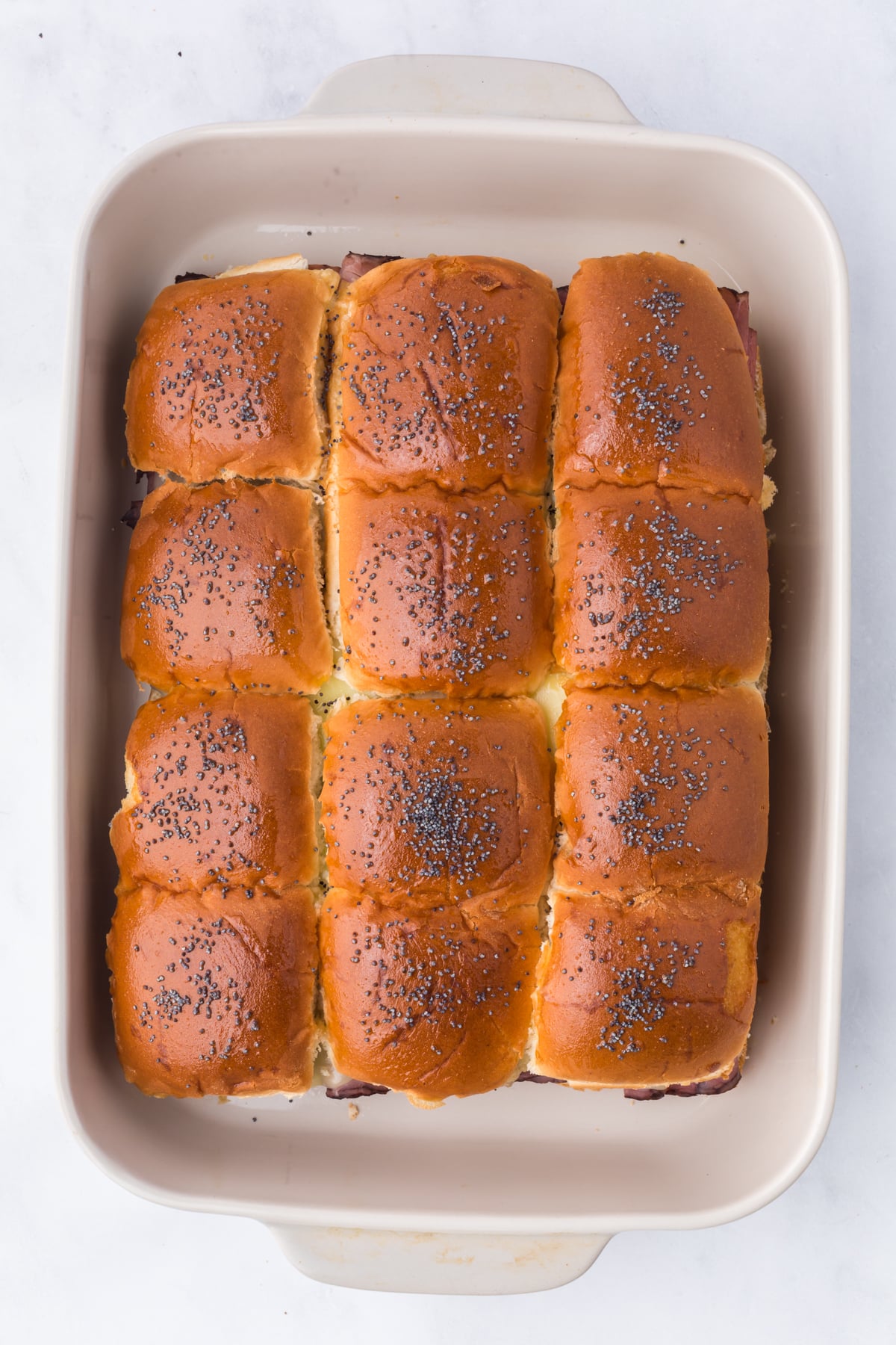 Freshly baked sliders in casserole dish.