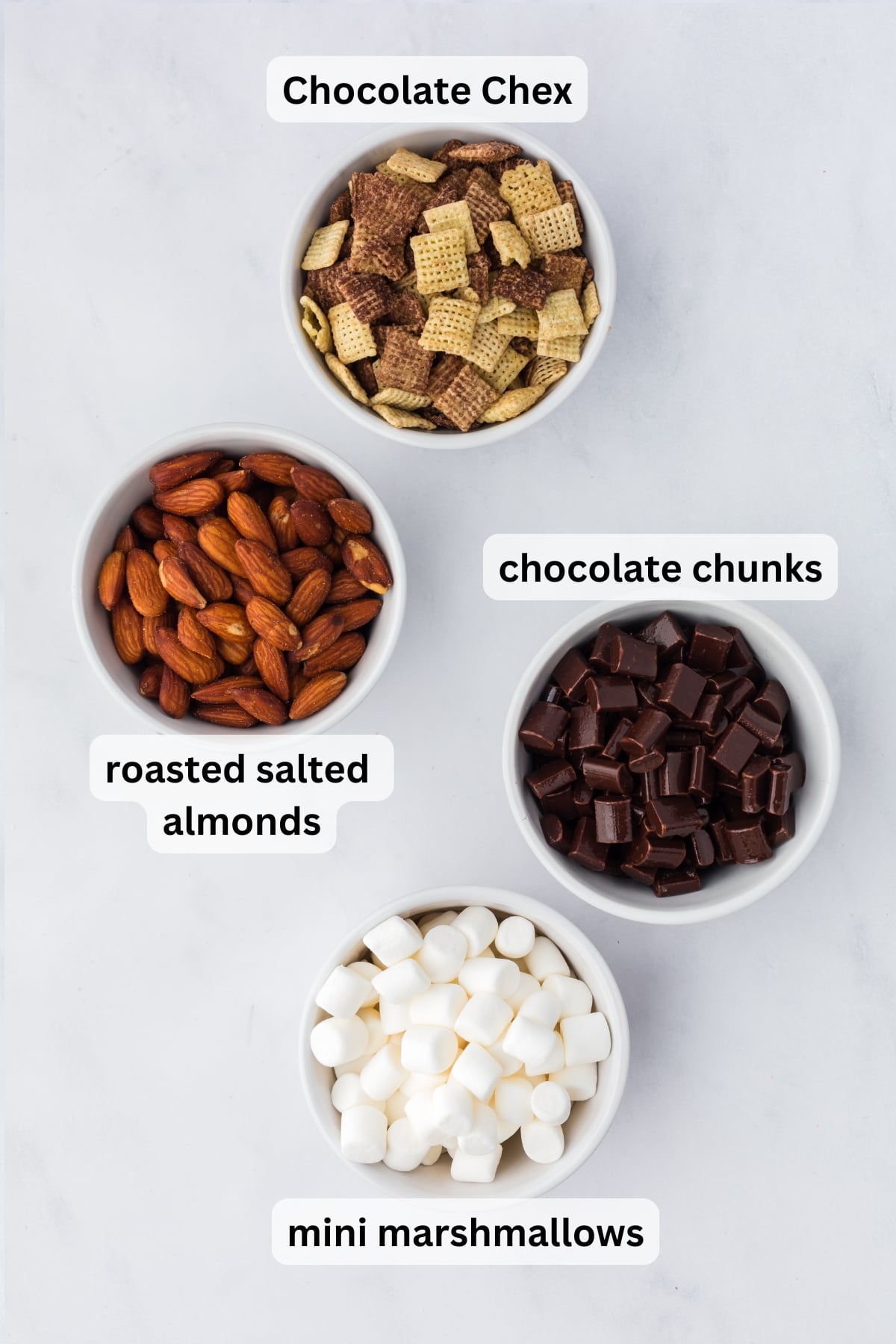 All of the ingredients needed to make Rocky Road Trail Mix in bowls on a table.