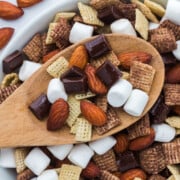 a wooden spoonful of Rocky Road Trail Mix held above a bowlful.