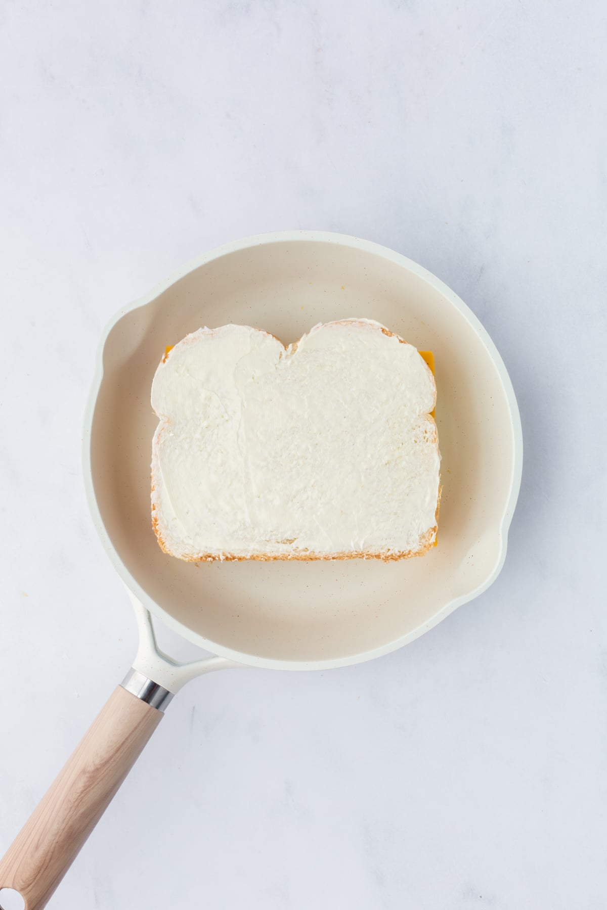 Remaining slice of cheese added and topped with slice of buttered bread, butter side up.