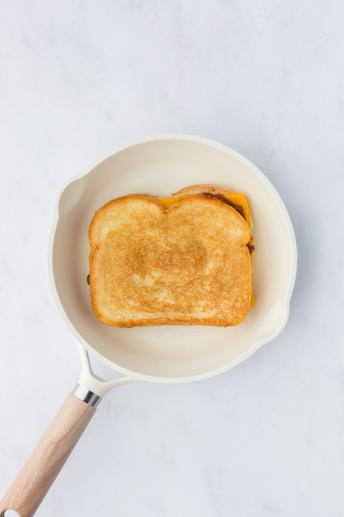 Cooked grilled cheese in skillet.