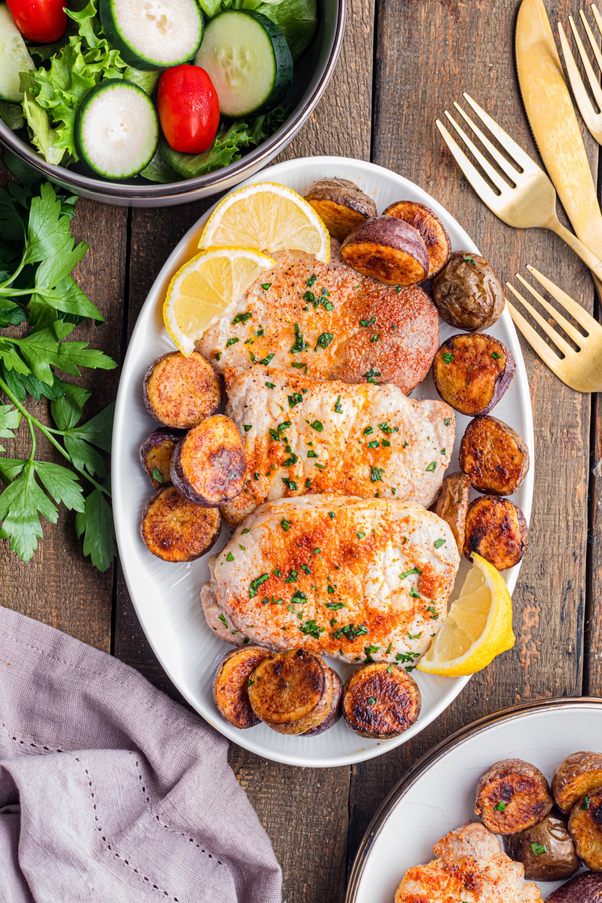 The pork chops and potatoes on a oval dish.