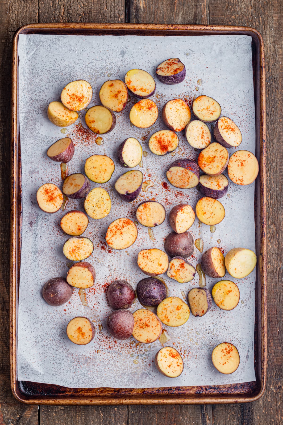 Sliced baby potatoes on a prepared baking sheet.