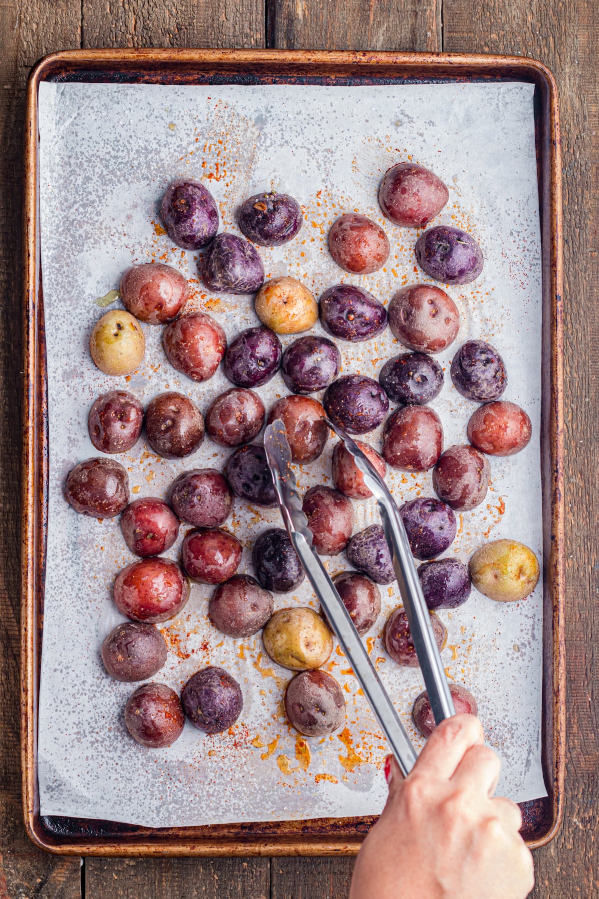 The potatoes arranged face down on the baking sheet.