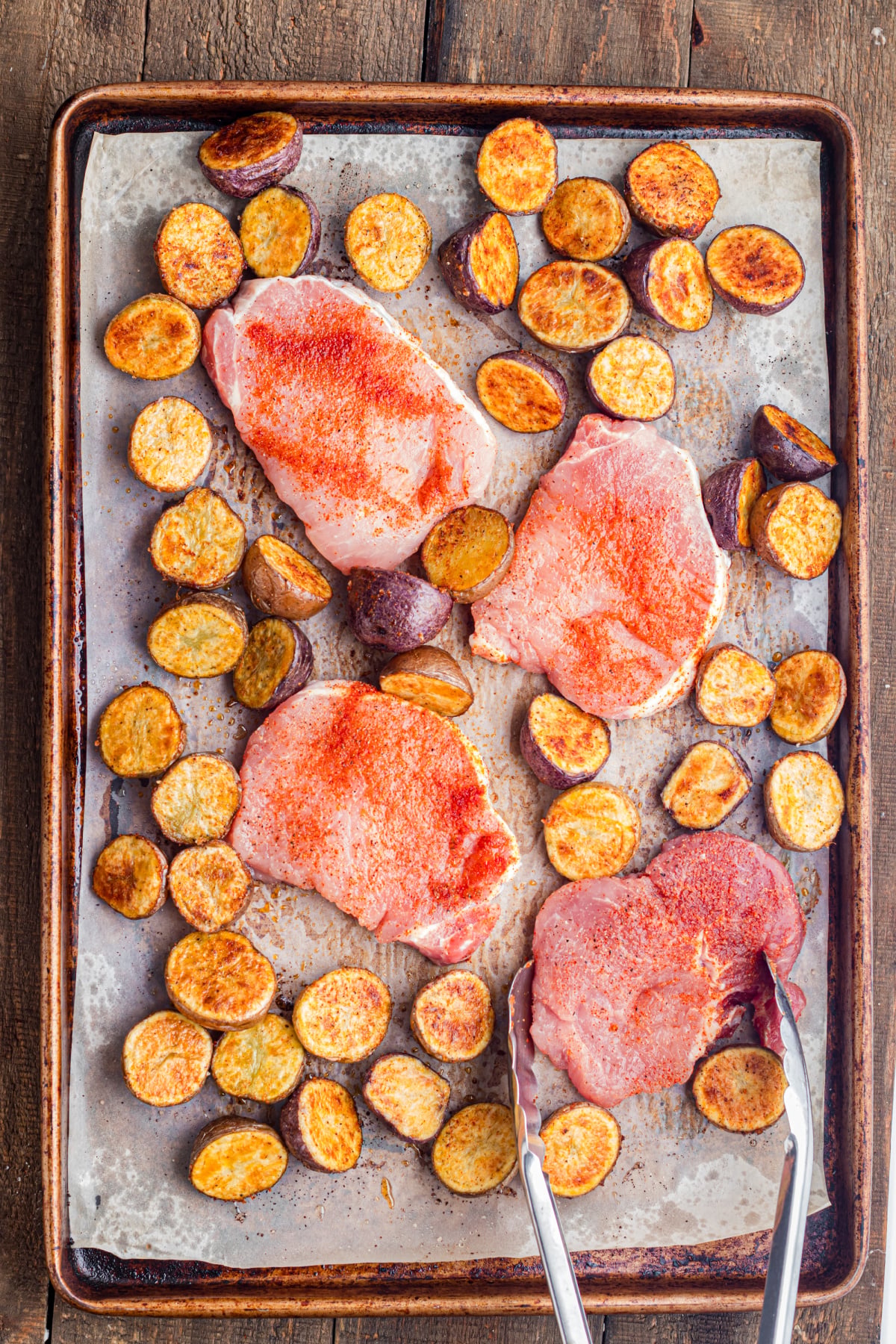 The pork chops added to the baking sheet.