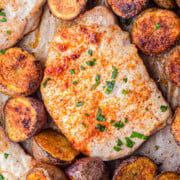 Baked pork chops and potatoes on a sheet pan.